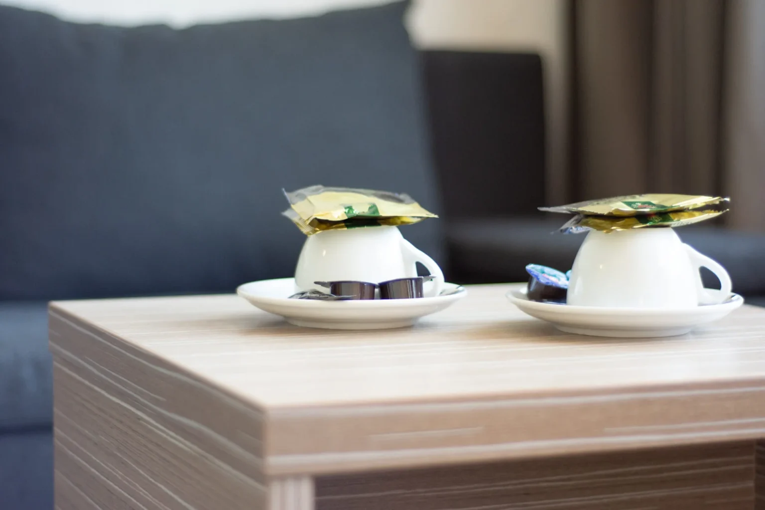 Kaffetassen mit Kaffeepads auf einem Sofatisch