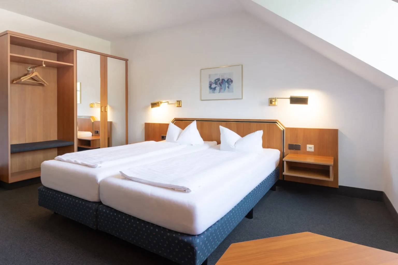 Ansicht auf das Doppelbett mit großer Garderobe im Hintergrund