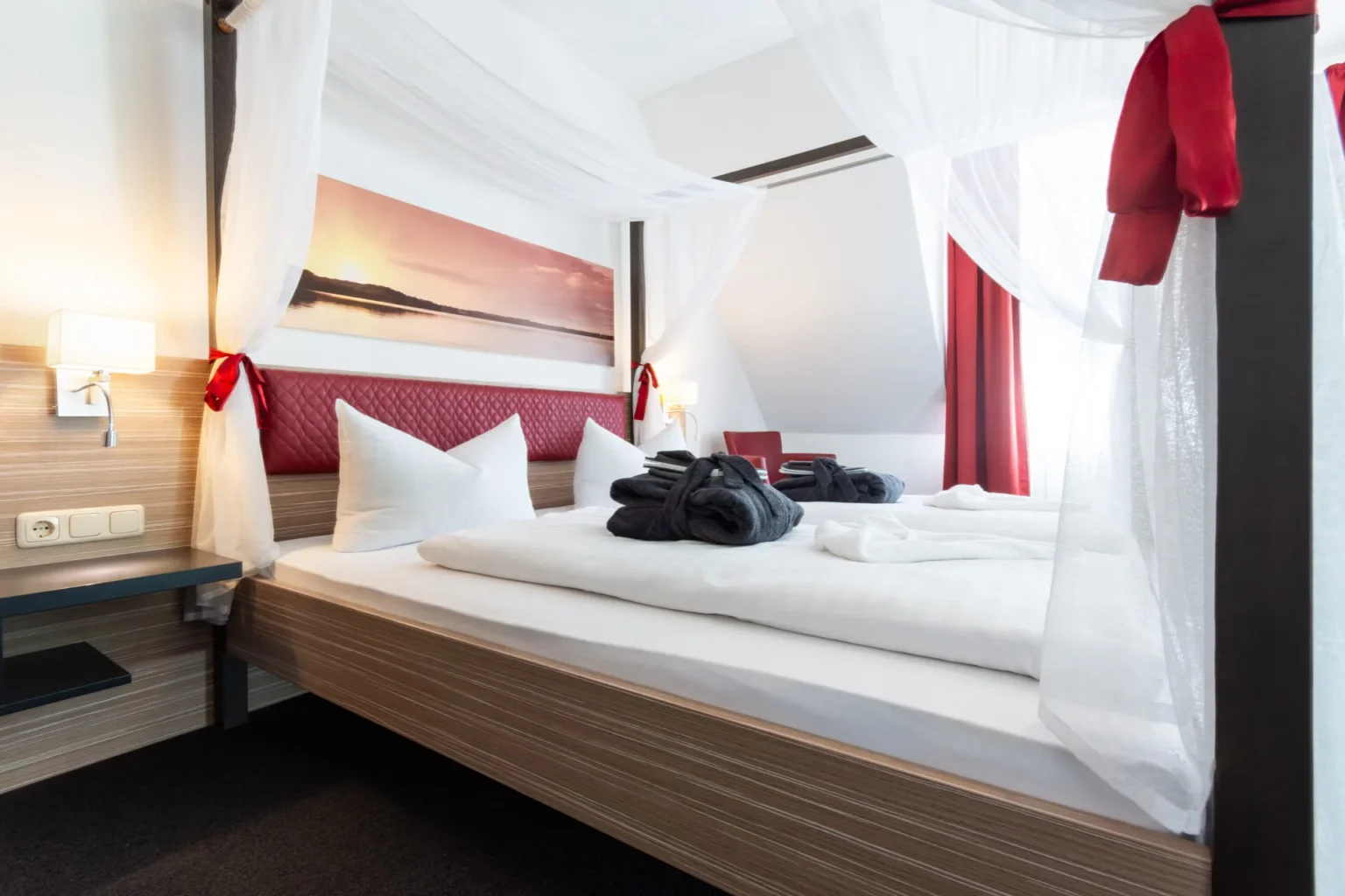 Ansicht von der Seite in das Bett mit Kopfkissen und Decken